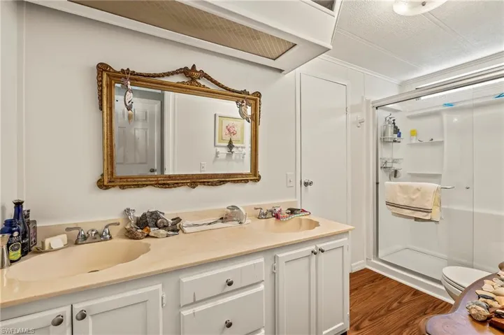 Bathroom with hardwood / wood-style flooring, vanity, a textured ceiling, and walk in shower