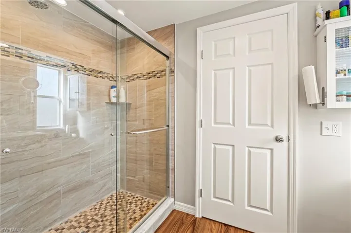 Bathroom featuring hardwood / wood-style flooring and walk in shower
