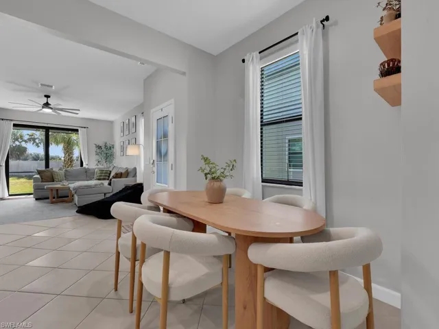 Dining area with light tile patterned floors and a ceiling fan