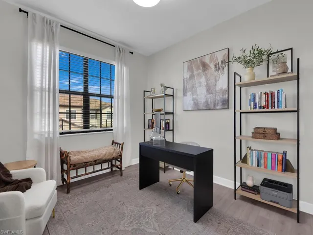 Office area with light wood-style flooring and baseboards