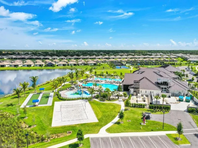 Aerial view of residential area featuring a pool and a nearby body of water