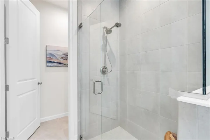 Large shower with frameless enclosure and a private water closet.