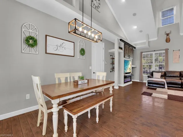 Dining area featuring dark wood finished floors, a high ceiling, and recessed lighting