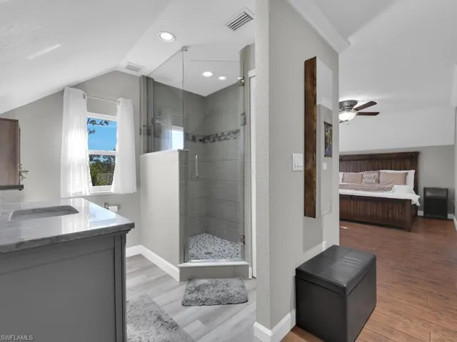 Ensuite bathroom featuring light wood-style flooring, a shower stall, vanity, a ceiling fan, and recessed lighting