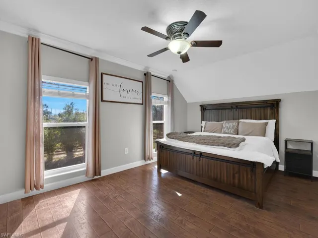 Bedroom featuring vaulted ceiling, wood-type flooring, and ceiling fan