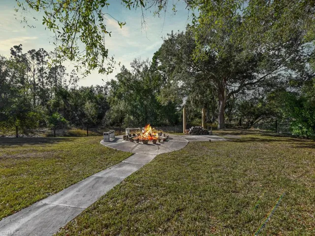 View of green lawn featuring view of scattered trees