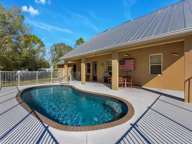 View of pool with a patio and area for grilling