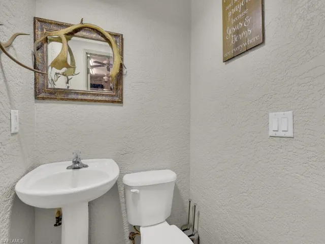 Bathroom featuring toilet and a textured wall