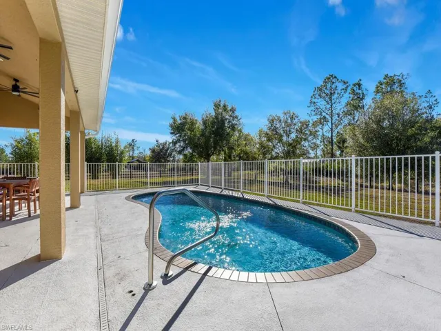 View of swimming pool with a patio and a fenced backyard