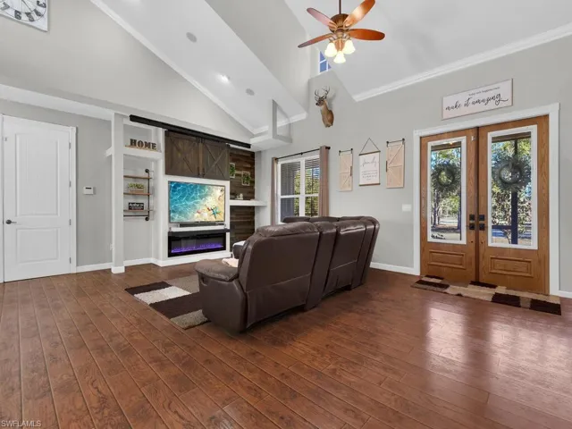 Living room featuring high vaulted ceiling, french doors, plenty of natural light, dark wood-style floors, and ceiling fan