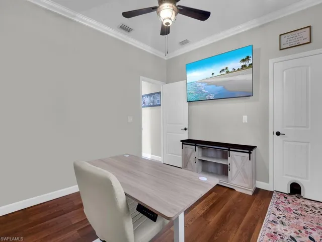Office area with ornamental molding, dark wood finished floors, and ceiling fan