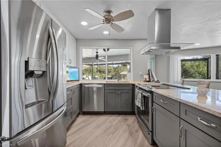 Island exhaust hood and stainless steel appliances, and pass-thru window.