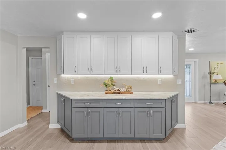 Two-tone cabinets, and light hardwood porcelain tile.