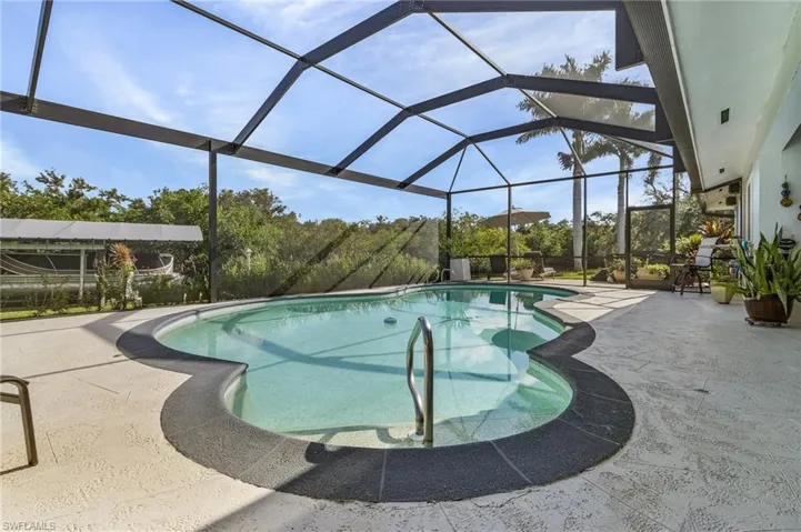 View of swimming pool and extra tall lanai screen.