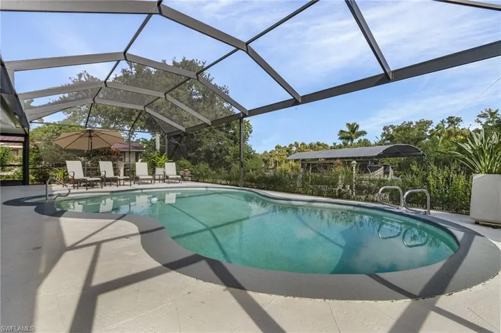 View of 29' x 17' swimming pool with screen enclosure and picture window.