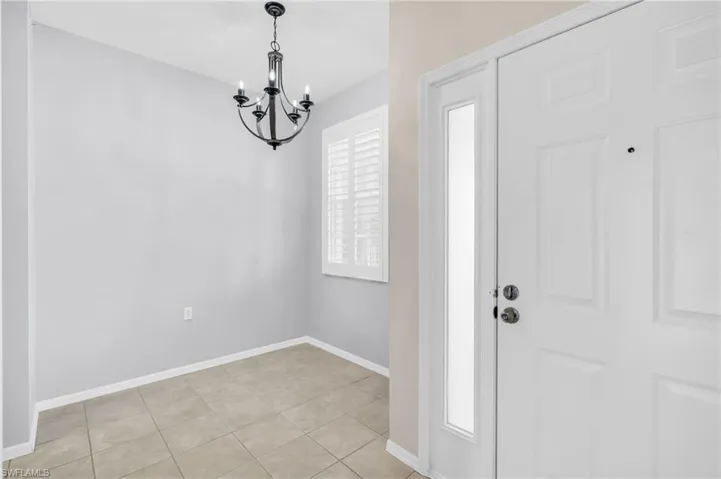Tiled entrance foyer featuring a notable chandelier