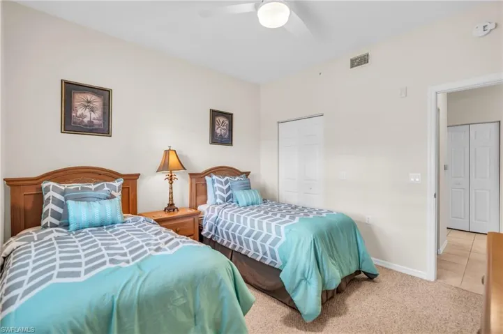 Tiled bedroom with ceiling fan and a closet