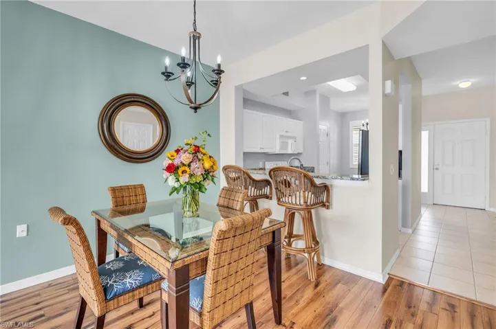 Dining space with light hardwood / wood-style flooring and an inviting chandelier