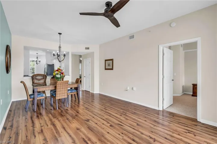 Carpeted dining room featuring ceiling fan with notable chandelier