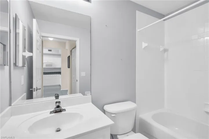 Full bathroom featuring toilet, tiled shower / bath combo, and vanity
