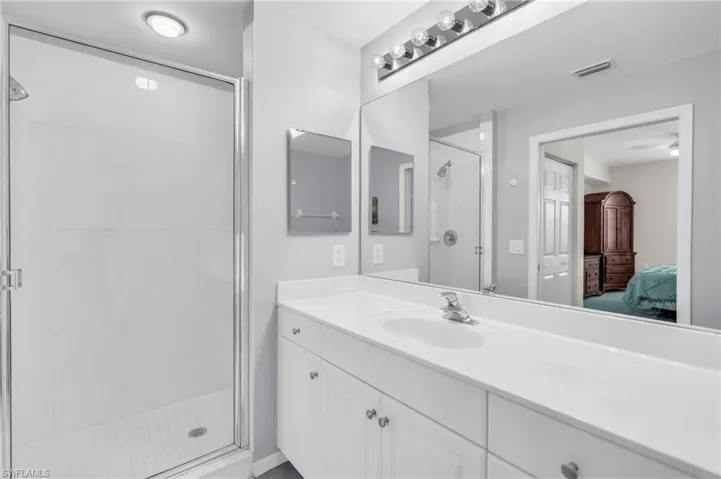 Bathroom featuring a shower with door and vanity