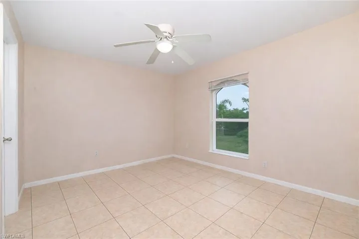 Empty room featuring ceiling fan and light tile patterned flooring