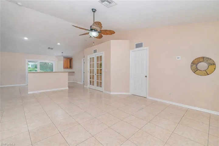 Spare room with vaulted ceiling, ceiling fan, light tile patterned floors, and recessed lighting