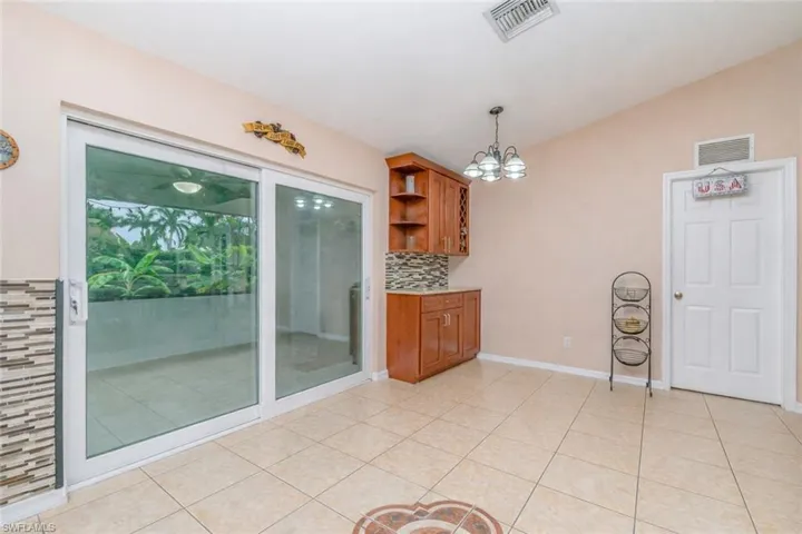 Unfurnished dining area featuring suspended lighting, lofted ceiling, and light tile patterned floors