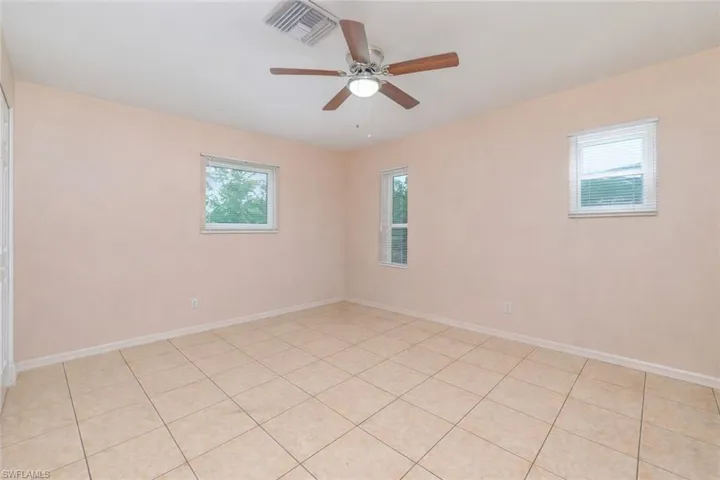 Spare room featuring a ceiling fan and light tile patterned flooring
