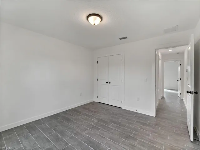 Unfurnished bedroom featuring wood finish floors, a closet, and a textured ceiling