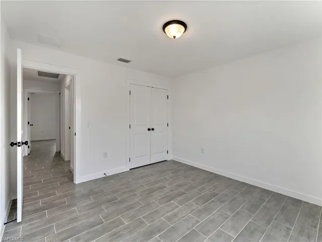 Unfurnished bedroom featuring wood tiled floors and a closet