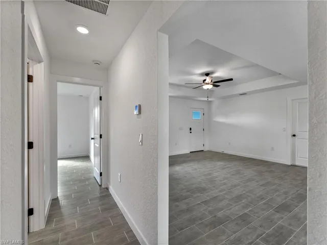 Hallway with a textured wall and wood tiled floors