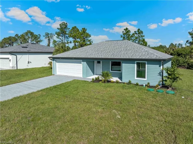 Ranch-style house with a shingled roof, concrete driveway, a front yard, and an attached garage