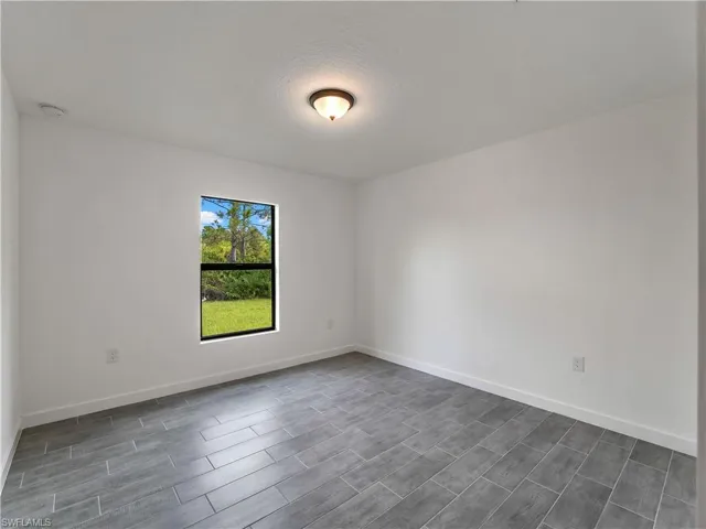 Empty room featuring wood finish floors and a textured ceiling