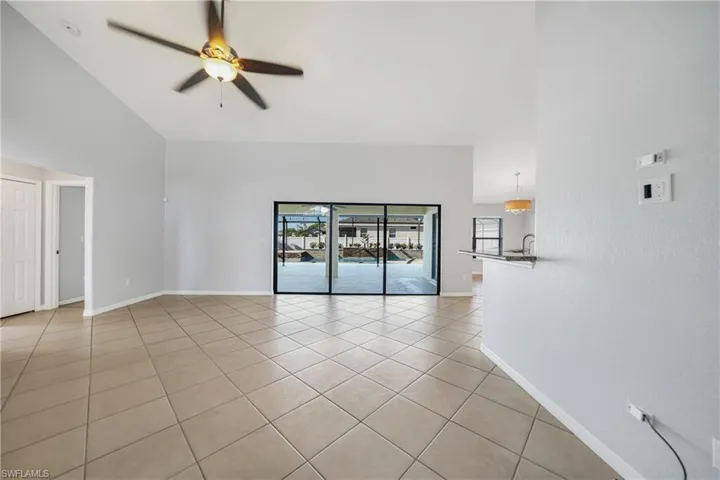 Spare room with ceiling fan, light tile patterned floors, and high vaulted ceiling