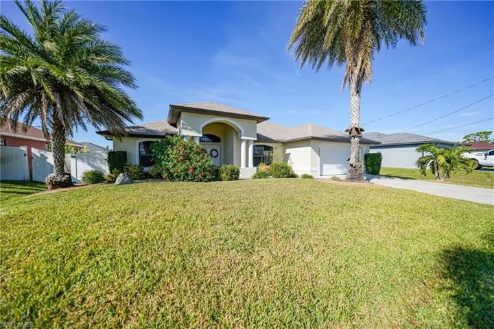 View of front of property featuring a garage and a front yard