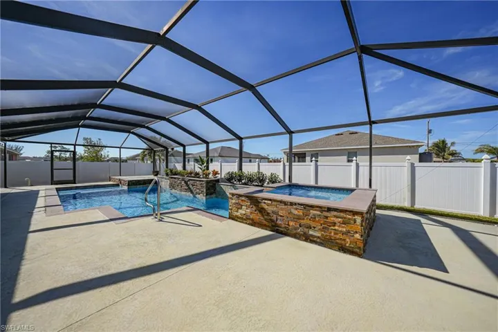 View of pool featuring an in ground hot tub, a patio, and glass enclosure