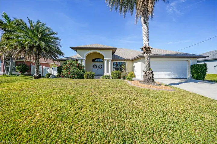 View of front facade featuring a front yard and a garage