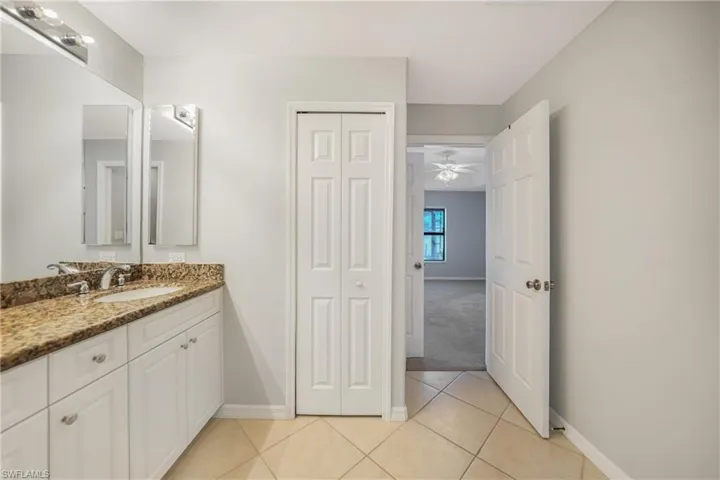 Bathroom featuring tile patterned floors, ceiling fan, and vanity