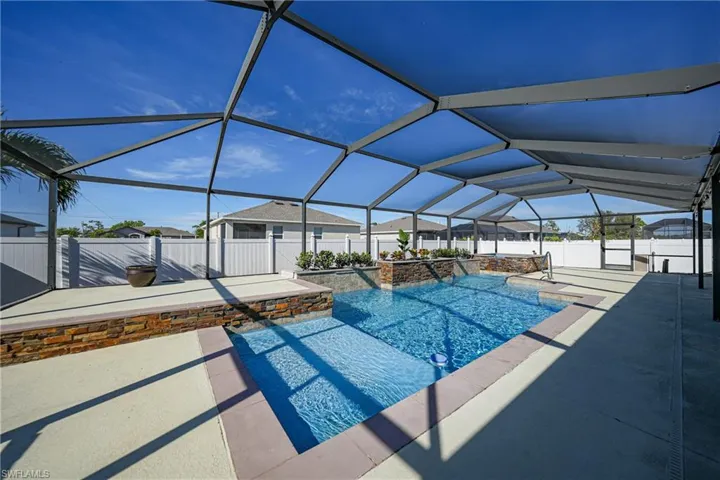 View of pool featuring pool water feature, a patio area, and a lanai