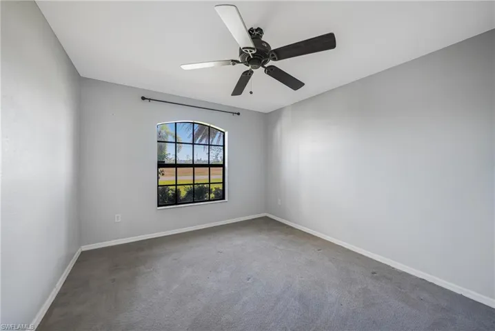 Carpeted spare room featuring ceiling fan