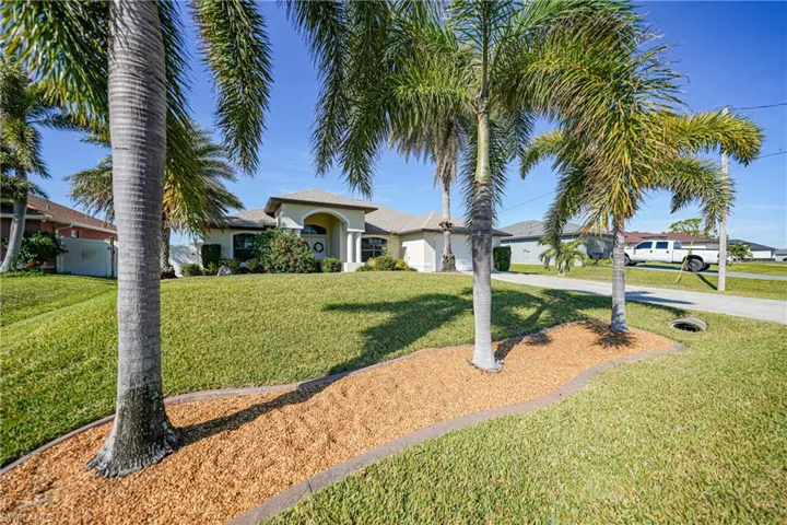 View of front of house featuring a front lawn and a garage