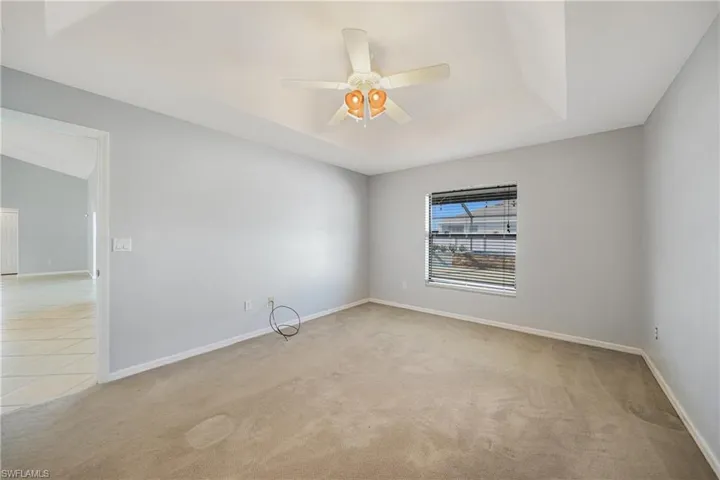 Carpeted spare room with ceiling fan