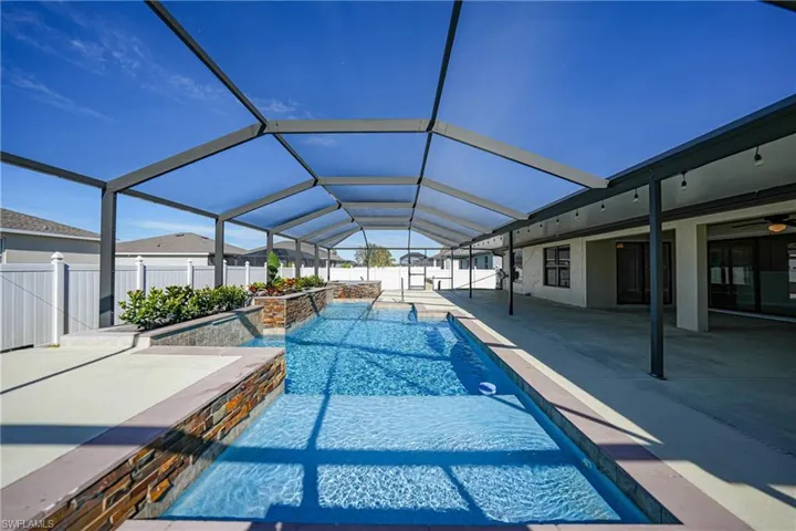 View of pool with a lanai, pool water feature, and a patio