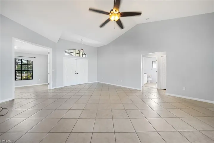 Unfurnished living room featuring ceiling fan, light tile patterned flooring, and high vaulted ceiling