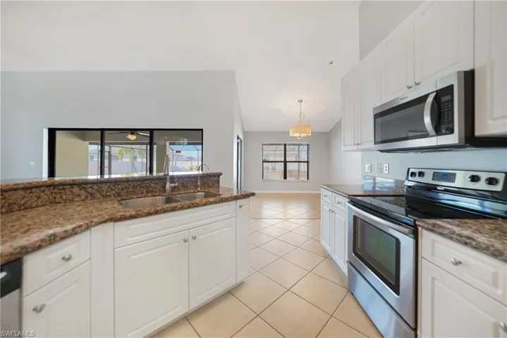 Kitchen featuring white cabinets, sink, and appliances with stainless steel finishes