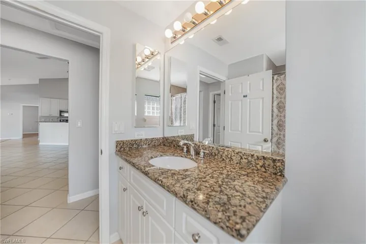 Bathroom with tile patterned flooring, vanity, and a shower with shower curtain