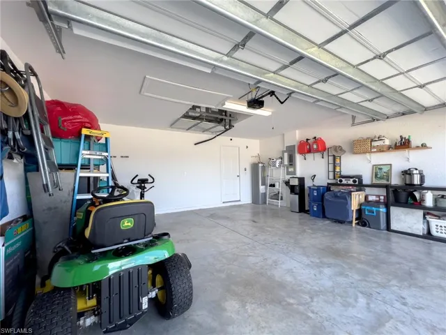Garage featuring water heater and electric panel