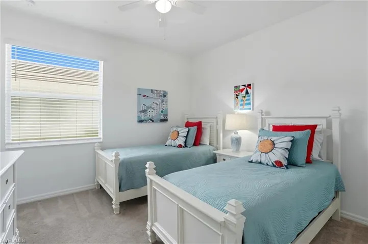 Bedroom with light carpet and a ceiling fan