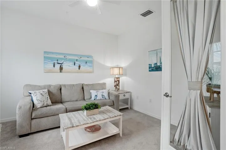 Living room with carpet and a ceiling fan